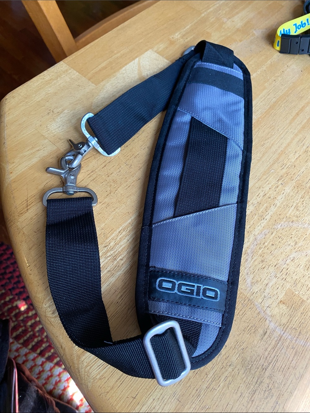 This is an OGIO replacement shoulder strap featuring a grey and black padded erg